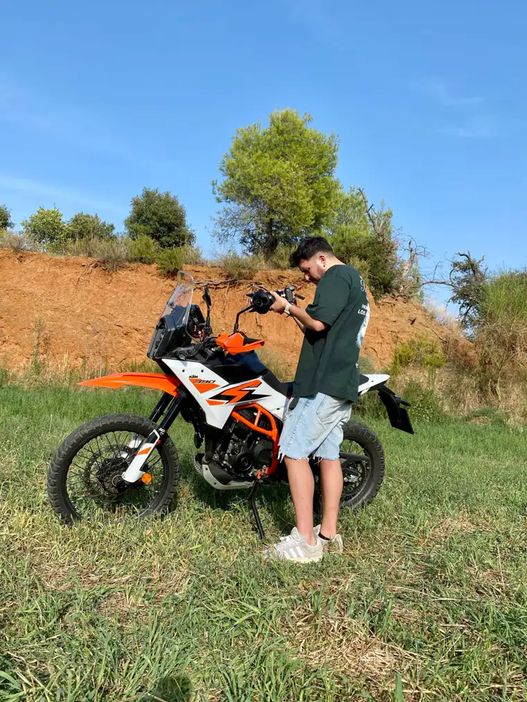 Fotógrafo practicando encuadres junto a una KTM de trail al aire libre